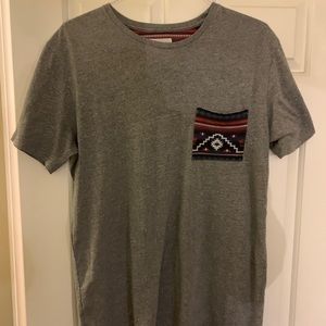 Grey tee shirt. Cool front pocket.
